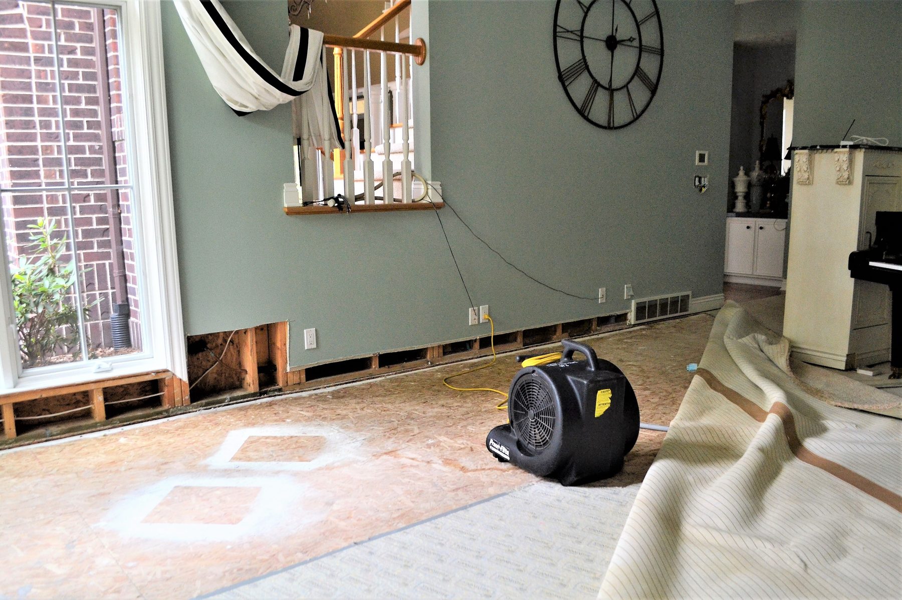 Air movers drying a water-damaged floor during restoration